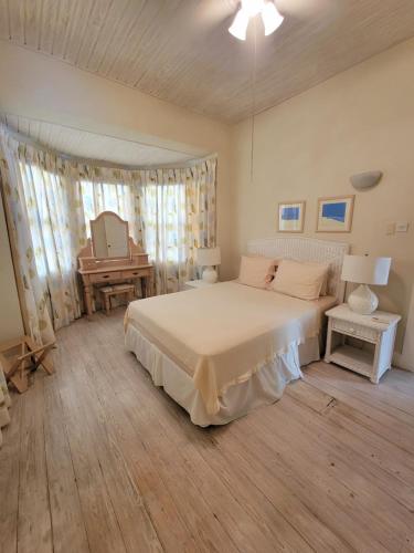 a bedroom with a white bed and a desk at Clariston in Bridgetown