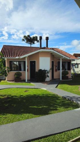 a house with a red roof and a driveway at Pousada Gramadense in Gramado