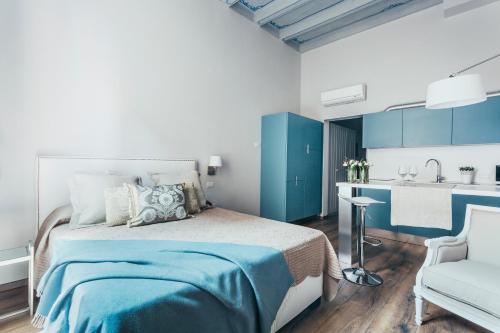 - une chambre bleue et blanche avec un lit et une cuisine dans l'établissement Opera Residence, à Bologne