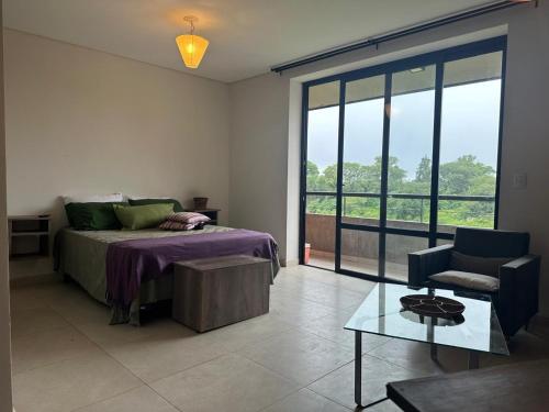 a bedroom with a bed and a couch and a chair at Monoambiente 2 Village Golf in Yerba Buena