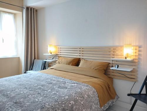 a bedroom with a large bed and two lamps at vaste T2 en Auvergne in Vic-le-Comte