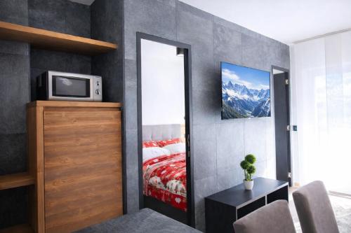 a bedroom with a bed with a mirror and a tv at CASA IBEX - Residence Veronza con piscina, Dolomiti Affitti in Cavalese