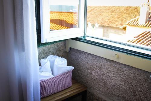 a window with a basket of towels next to a window at Casa Pires Mateus in Monsanto