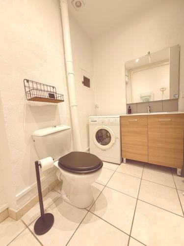 a bathroom with a toilet and a washing machine at Les nids de Lagasse in Agen