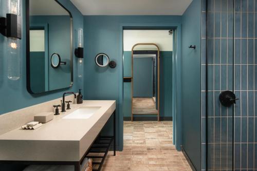 a bathroom with a sink and a blue wall at The Junto Hotel in Columbus
