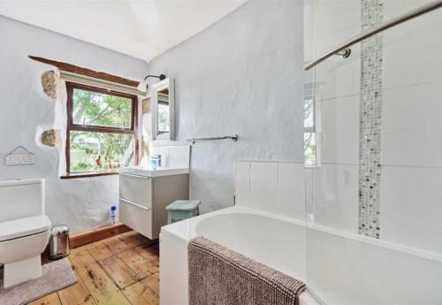 a white bathroom with a tub and a toilet at Tawnawood in Cardinham