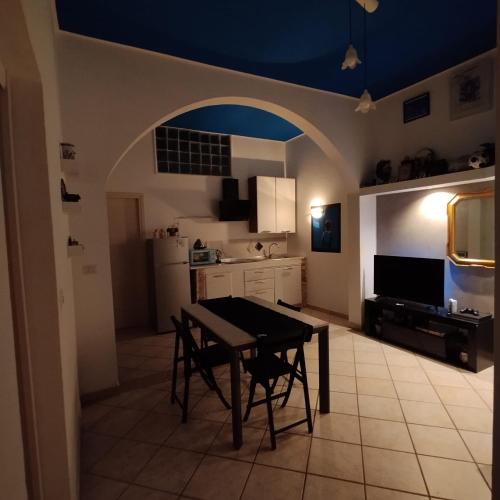 a kitchen with a table and chairs and a blue ceiling at Casaitalia in Capilungo