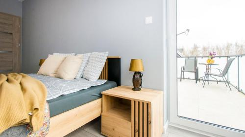 a bedroom with a bed and a balcony with a table at Prestige House Jacuzzi & Sauna in Gdańsk