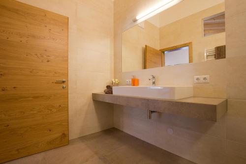 ein Bad mit einem Waschbecken und einem Spiegel in der Unterkunft Alps 3000-1 in Umhausen