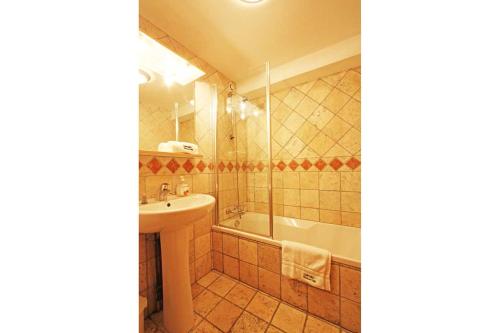 シャモニー・モンブランにあるLa Ferme des Praz apartment - Chamonix All Yearのバスルーム(シンク、シャワー、バスタブ、シンク付)