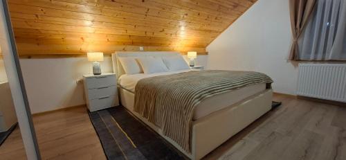 a bedroom with a bed and a wooden ceiling at Monte Symphony in Rakovica