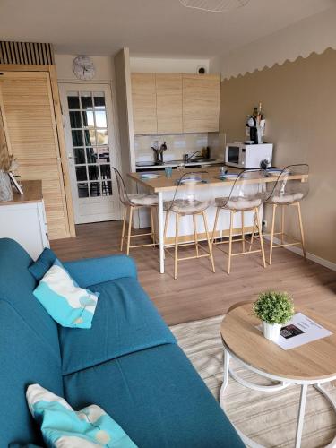 salon z niebieską kanapą i kuchnią w obiekcie La BRIGANTINE 3 w mieście Fort-Mahon-Plage