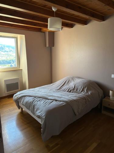 a bed in a bedroom with a window at Gîte Les Vignes au Cheylard in Le Cheylard