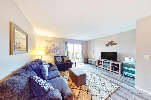 a living room with a blue couch and a tv at Vineyards 2909 #3 in Branson