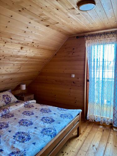 a bedroom with a bed in a wooden room at Brvnare Nikolić in Zlatibor