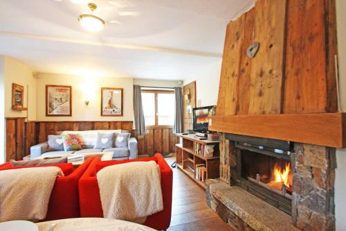 a living room with a red couch and a fireplace at La Ferme des Praz apartment - Chamonix All Year in Chamonix