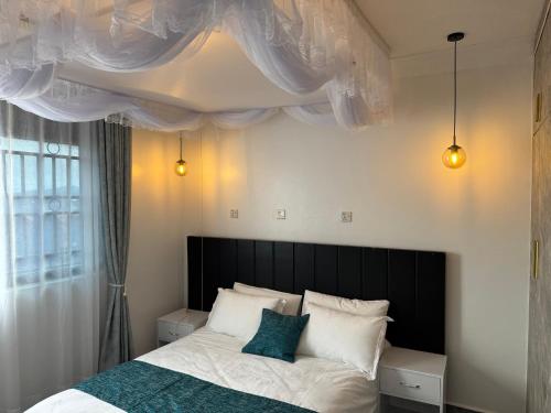 a bedroom with a bed with a black headboard at Elp Living in Hoima