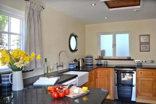 a kitchen with a counter with fruits and vegetables on it at Pebbles in Cadgwith