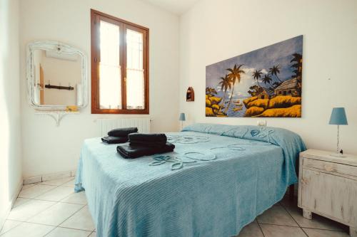 a bedroom with a bed with a blue blanket at Seaside Beach House with Private Parking in Punta Marina