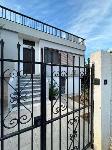 a black wrought iron gate in front of a house at Minimalist Serenity Vravrona - Airport Stay in Vravrona