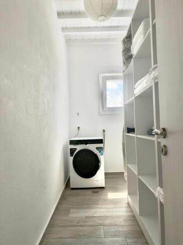 a laundry room with a washing machine in it at Villa Greystone & Sky Mykonos in Tourlos