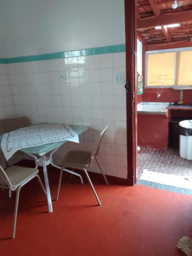 a room with a table and two chairs and a bathroom at casa charme e praticidade in Campos do Jordão