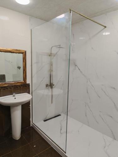 a bathroom with a glass shower and a sink at M&W Hostel in Yerevan