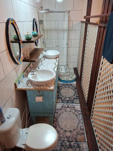 a bathroom with two sinks and a toilet and a mirror at 65 Rowweklip in Jongensfontein