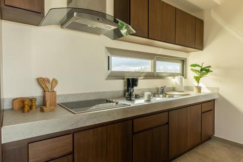 a kitchen with a sink and a window at La Poza Suites in Isla Mujeres
