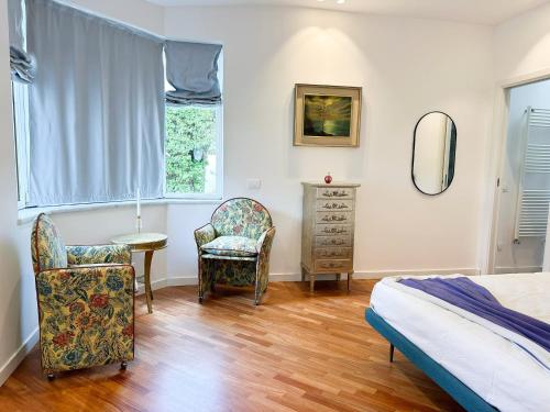 a bedroom with a bed and a chair and a dresser at Mondello Luxury villa in Palermo