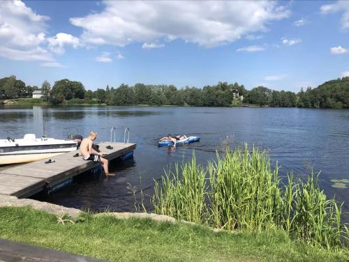 a group of people sitting on a dock on a lake at Dalälven Strand in Södersätra