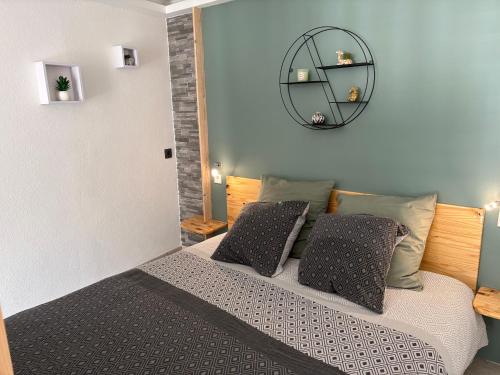 a bedroom with a bed with two pillows and a mirror at Coconning studio in Plauzat