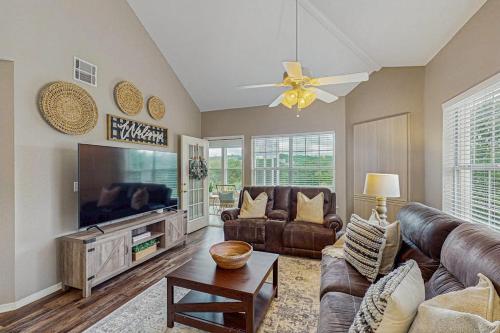 a living room with leather furniture and a flat screen tv at On the Green in Branson