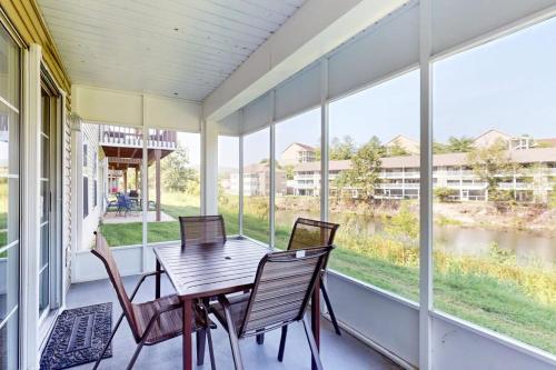 a screened porch with a wooden table and chairs at Fall Creek Resort Pond View Escape in Branson