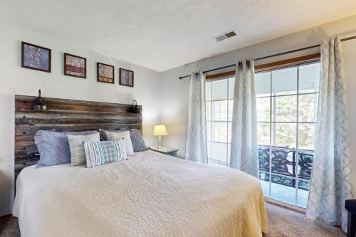 a bedroom with a bed and a large window at Fall Creek Resort Pond View Escape in Branson