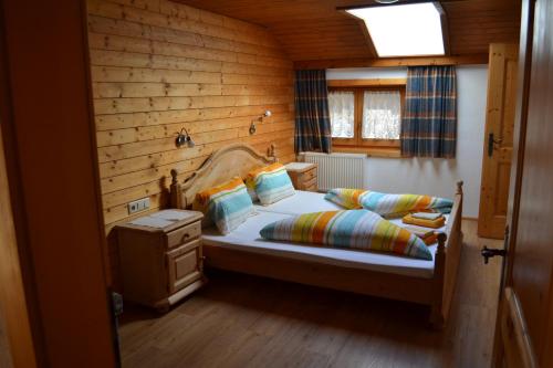 ein Schlafzimmer mit einem Bett mit einer Holzwand in der Unterkunft Bohrerhof in Ahrnbach