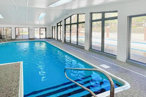 a large swimming pool with blue water in a building at Thousand Hills - Family Getaway in Branson