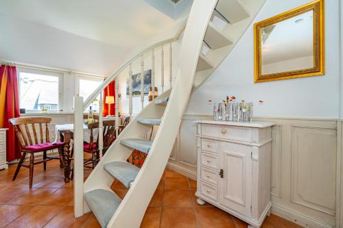 a spiral staircase in a dining room with a table at Wattblick in Braderup