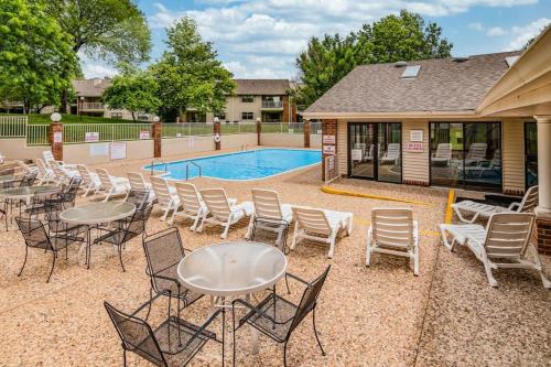 a patio with tables and chairs next to a pool at Thousand Hills - Family Getaway in Branson