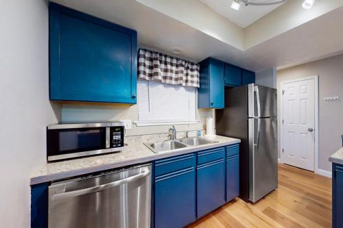 a kitchen with blue cabinets and a stainless steel refrigerator at Overlook Retreat, Apt. 3 in Branson