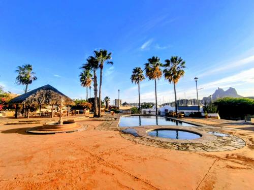 a park with palm trees and a small pond at Casa Villa Serena 8 in San Carlos