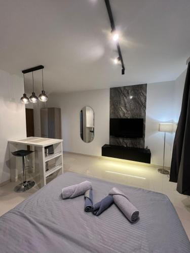 ein Schlafzimmer mit einem Bett, zwei Hausschuhen und einem Schreibtisch in der Unterkunft LiboroView in Niš