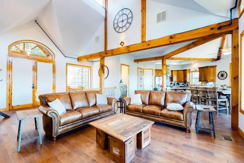a living room with two leather couches and a table at Treetop View Sanctuary in Branson