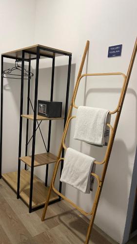 a towel rack with two towels on a shelf at Lali Beach Hotel Boutique in Sonsonate