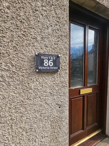 a sign on the side of a building next to a door at Kirkwall Flat 1 in Orkney
