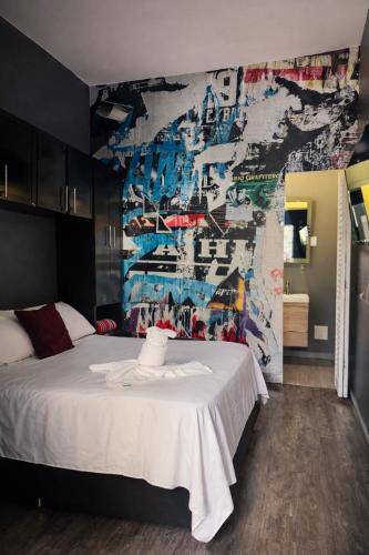 a bedroom with a white bed and a mural at Seven Nights Hostel Cartagena in Cartagena de Indias