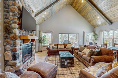 a living room with couches and a stone fireplace at Cozy Cove Lodge in Branson