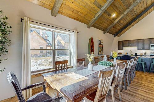 a dining room with a wooden table and a large window at Cozy Cove Lodge in Branson