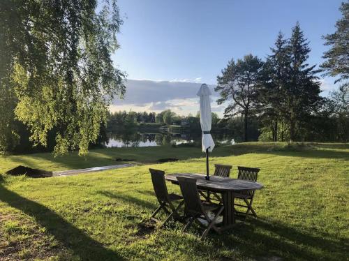 a table with an umbrella and chairs in a field at Dalälven Strand in Södersätra