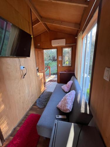a small living room with a couch and a tv at Cabañas Villegas C2 in Hornopiren
